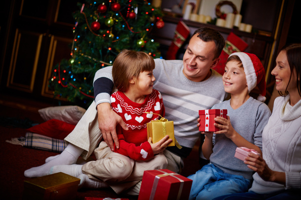 Family with gifts on Christmas evening - Foto, imagen