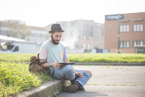 Современный человек с помощью планшета и курения сигареты
 - Фото, изображение