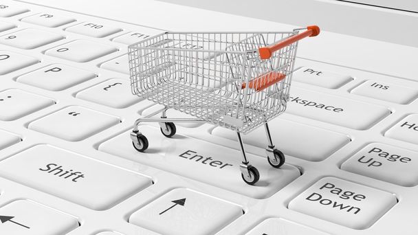 Shopping cart on white laptops keyboard  - Photo, Image