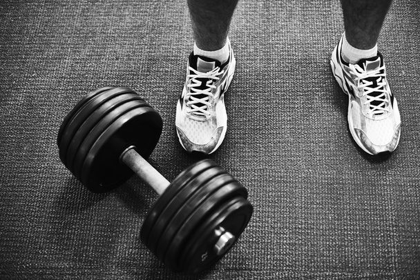 Man in sneakers and barbell - Фото, изображение