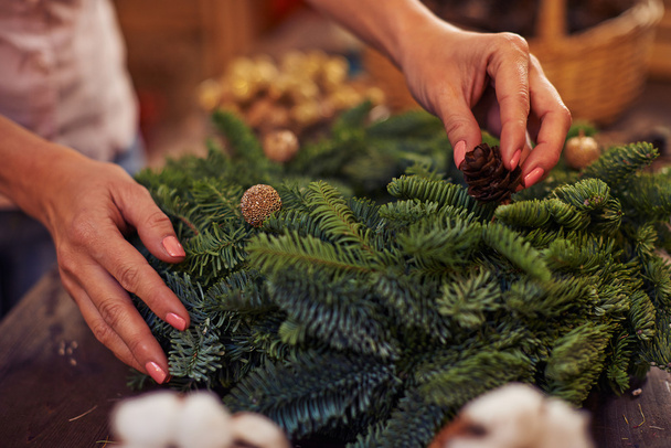 Female hands decorating coniferous wreath - Photo, Image