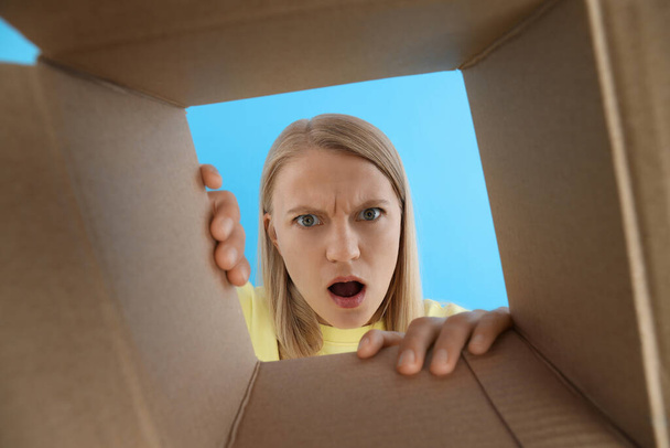 Концепція доставки, молода жінка дивиться в коробку
 - Фото, зображення