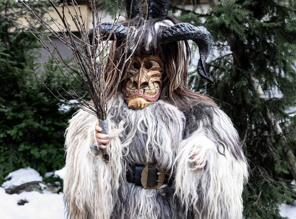 Πορτρέτο ενός αγοριού σε ένα κοστούμι Krampus, δέρμα ζώου, κέρατα και μια ξύλινη μάσκα, Αυστρία, Σάλτσμπουργκ. Υψηλής ποιότητας φωτογραφία - Φωτογραφία, εικόνα