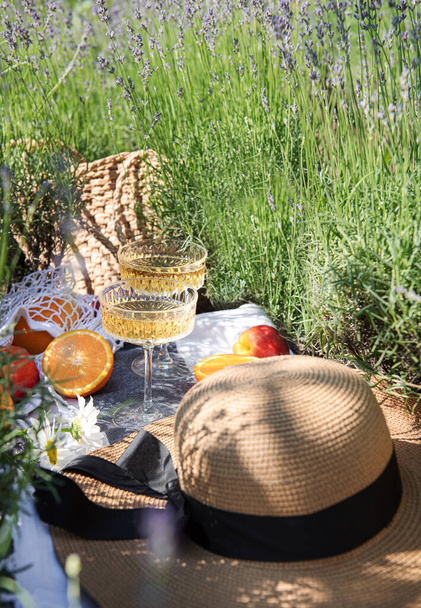 Summer picnic on a lavender field with champagne glasses and fruits - Foto, Bild