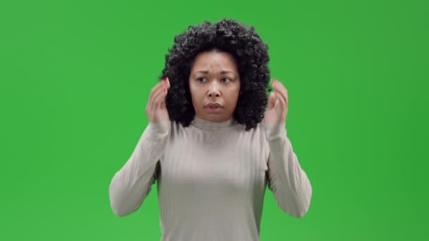 アフリカ系アメリカ人女性は手の神経の恐怖の負の感情で耳をカバー緑の画面に隔離 - 映像、動画