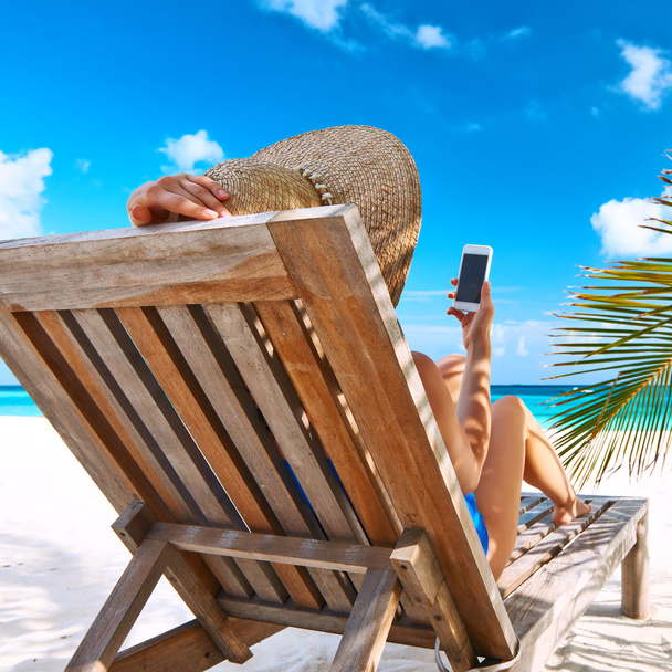 Женщина с мобильным телефоном на пляже
 - Фото, изображение