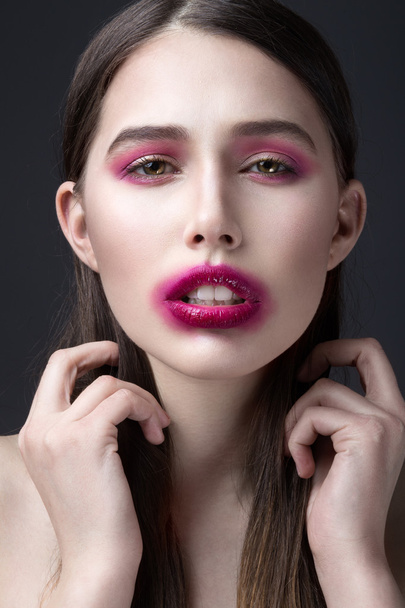 Chica con lápiz labial rosa manchada en su cara. Maquillaje creativo
. - Foto, imagen