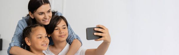 Azji chłopiec biorąc selfie z siostrą i mamą w domu, baner  - Zdjęcie, obraz