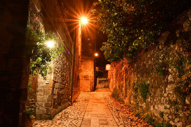 Wąska uliczka wśród starych kamiennych domów średniowiecznej dzielnicy miasta Caserta, Włochy. - Zdjęcie, obraz