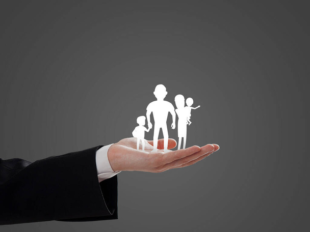 Familie pictogram geplaatst over de zakenman hand, verzekering, handel en bedrijfsimago - Foto, afbeelding