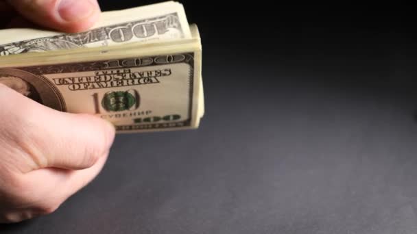 Чоловіча рука тримає доларові купюри і рахує їх на чорному тлі. Фінансові витрати, закупівлі, накопичені заощадження. крупним планом 4k відео
 - Кадри, відео