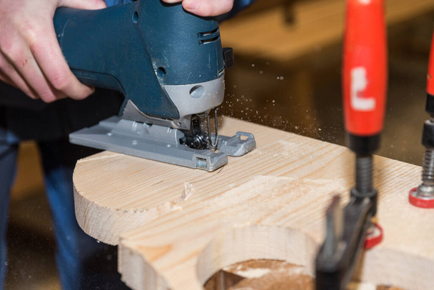Tischler sägt Holzbrett mit elektrischer Säge - Tischler und Stichsäge - Foto, Bild