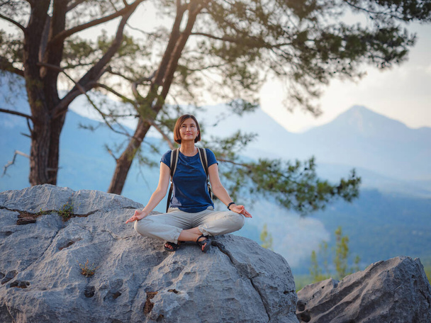 vrouw reiziger wandelen door Lycian Way trail bergen in Turkije in de buurt van Antalya. Vrouw mediterend op yoga alleen in zonsopgang bergen. concept van spirituele ontspanning voor reizen. Harmonie met de natuur. - Foto, afbeelding