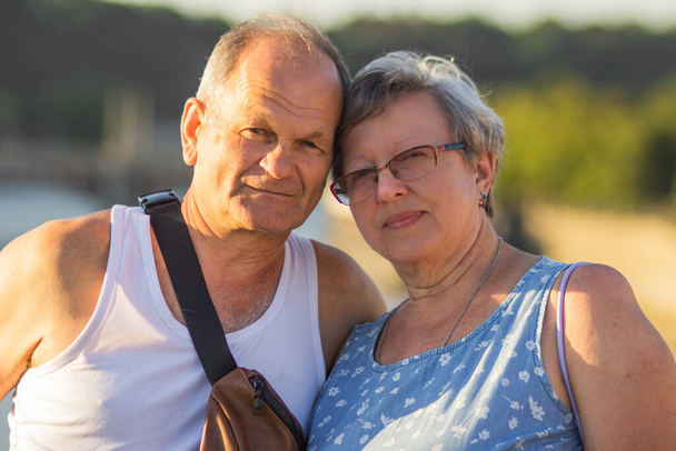 Glückliche Senioren, die auf den Straßen der Prager Altstadt spazieren gehen. Lächelnde ältere Eheleute, die in den Sommerferien verreisen. Aktive Senioren und Reisekonzept. Lebensstil. - Foto, Bild