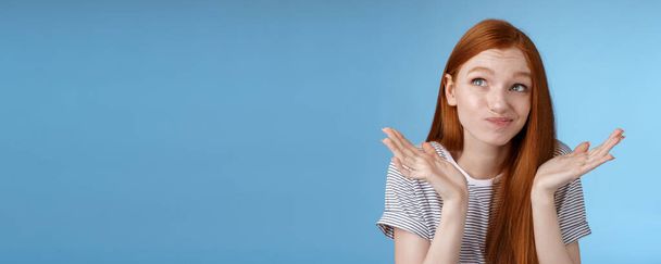 Awkward uncomfortable attractive redhead popular girl trying think up excuse feeling reluctant uncertain standing doubtful shrugging spread hands sideways smirking look up hesitant. - Photo, Image