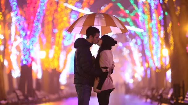 Paar mit Koffer küsst sich nachts in Gasse - Filmmaterial, Video