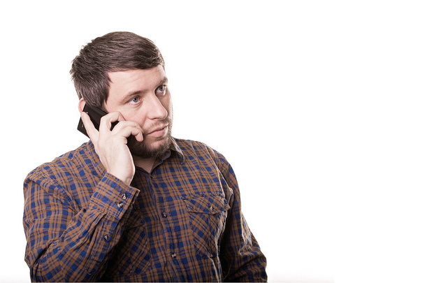 Business man in a plaid shirt talking on the phone isolated on w - Foto, Bild