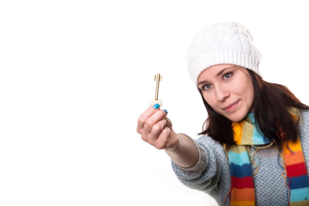 The key is in your hands. Beautiful girl in a knitted cap holds  - Foto, immagini