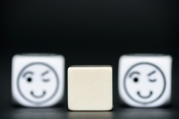 blank dice with emoticon dice (happy, blinking) in background - Photo, Image