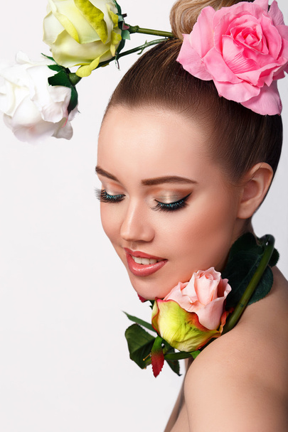 Chica modelo de belleza de moda con flores de rosa cabello. Maquillaje y peinado. Peinado.Ramo de hermosas flores en la cabeza de la señora
 - Foto, imagen