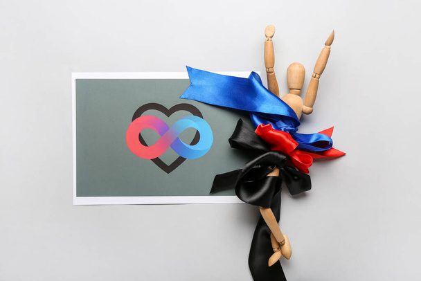 Paper sheet with symbol of polyamory, wooden mannequin and ribbons on grey background - Photo, Image
