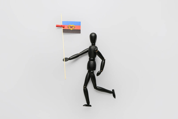 Czarny manekin z flagą poliamoryczną na szarym tle - Zdjęcie, obraz