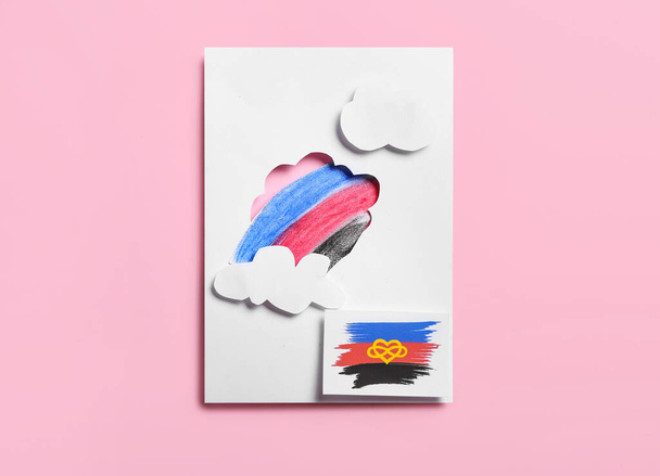 Feuilles de papier avec dessin, nuages et drapeau en polyamide sur fond rose - Photo, image