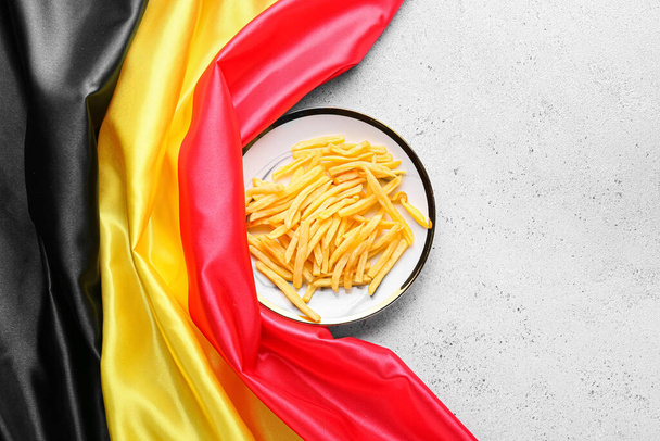 Flaga Belgii i talerz z frytkami na jasnym tle - Zdjęcie, obraz