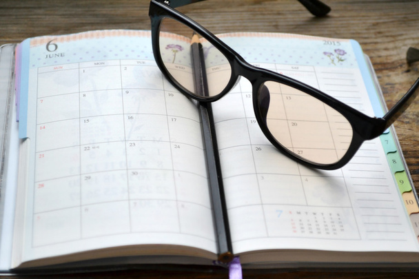 Un planificateur quotidien rétro vide avec crayon noir et lunettes de lecture
 - Photo, image