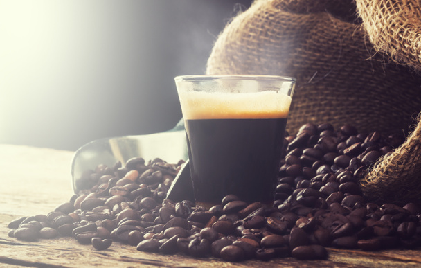 Espresso koffie in glas cup met koffie bonen. - Foto, afbeelding