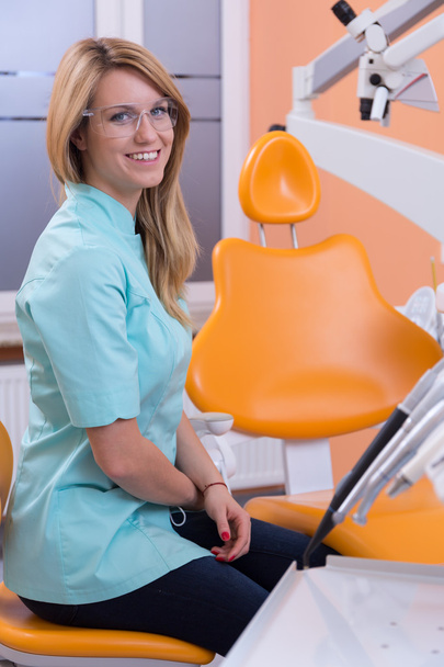 Siedząc na stołek dentystyczny dentysta - Zdjęcie, obraz