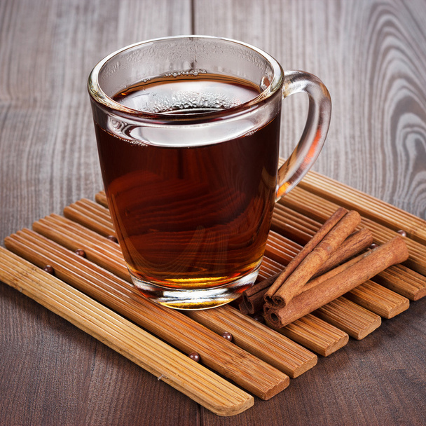 teacup with hot tea and cinnamon sticks - Valokuva, kuva