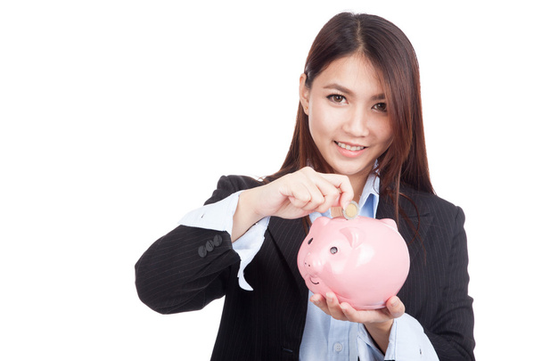 Young Asian businesswoman with a coin and piggy bank - Valokuva, kuva
