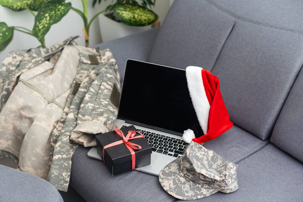 uniforme militar e um chapéu de Santa com um laptop. - Foto, Imagem