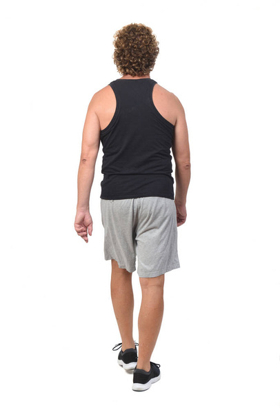 πίσω όψη ενός άνδρα με αθλητικά ρούχα περπάτημα σε λευκό φόντο - Φωτογραφία, εικόνα