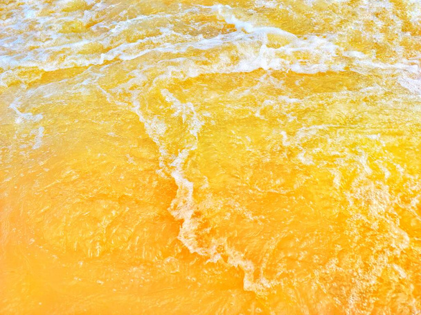 Defocus blurred transparent orange colored clear calm water surface texture with splash, bubble. Shining orange water ripple background. Surface of water in swimming pool. Orange bubble water, splash. - Photo, Image