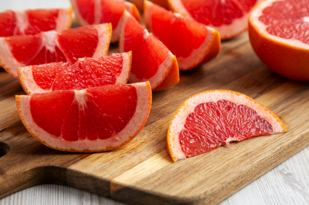 Organic Red Ruby Grapefruit on a Wooden Board, low angle view. Close-up. - Photo, Image
