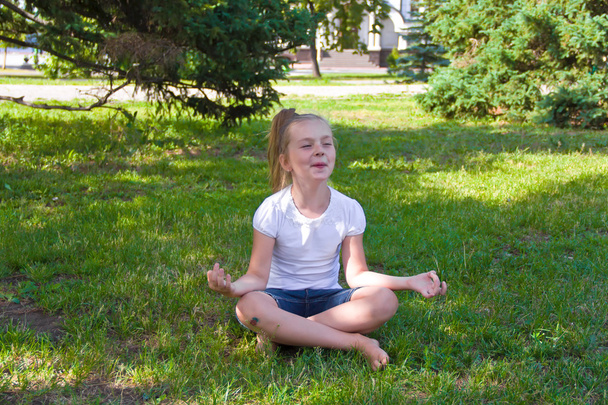 Cute girl in lotus pose with sore knee - Photo, image