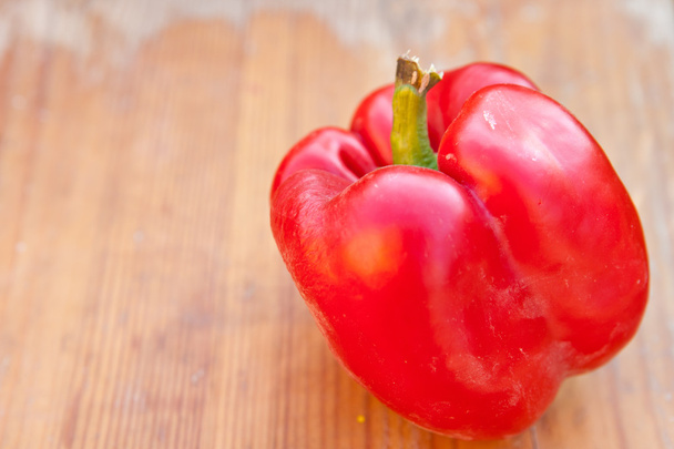 Red pepper on a wooden background, shallow depth of field - Foto, afbeelding