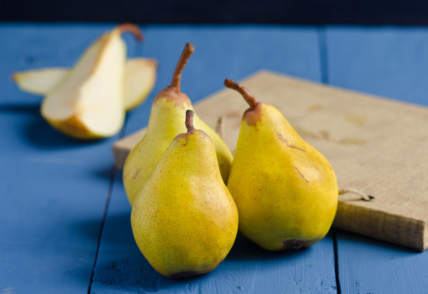 Yellow pears on a blue wooden table  - Foto, Bild