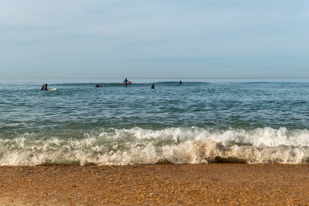 Einige Surfer im Meer genießen die Wellen - Foto, Bild