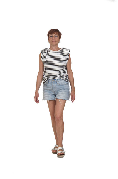  front view of a full portrait of a middle aged woman walking on white background - Valokuva, kuva
