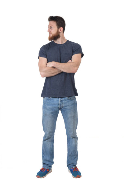 vista de un hombre de pie con los brazos cruzados y mirando hacia otro lado sobre fondo blanco - Foto, imagen