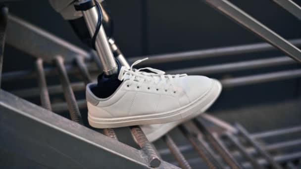 Медленный взгляд на человека с протезными ногами и белыми кроссовками, сидящего на металлической лестнице - Кадры, видео