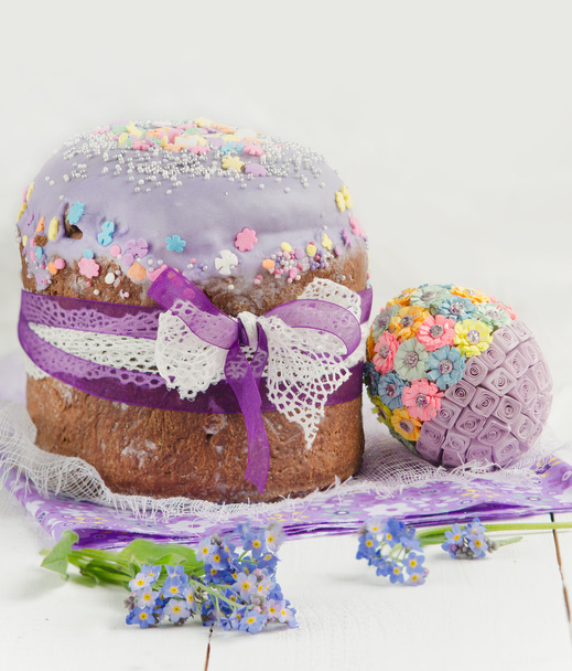 Крупный план традиционных пасхальных тортов с цветочным оформлением на деревянном столе
 - Фото, изображение