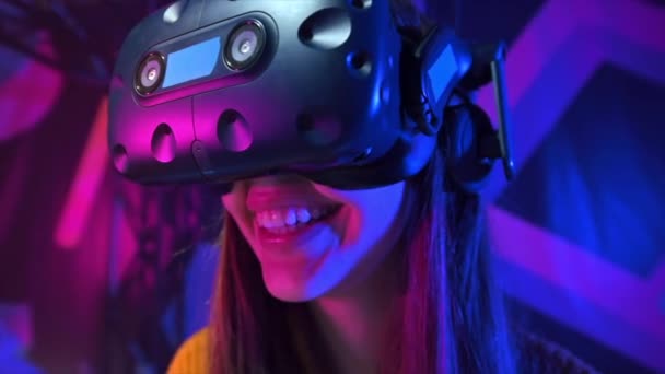 Close view of a joyful, smiling girl is playing on VR treadmill using helmet. Slow motion - Footage, Video