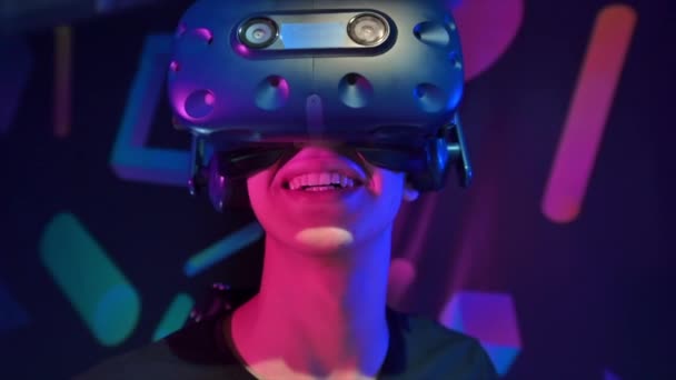 Close view of a joyful, smiling boy is playing on VR treadmill using helmet. Slow motion - Footage, Video