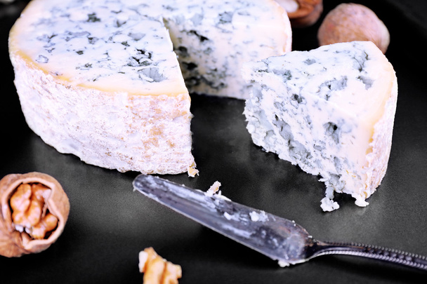 Blue cheese with nuts and blade on metal tray background - 写真・画像