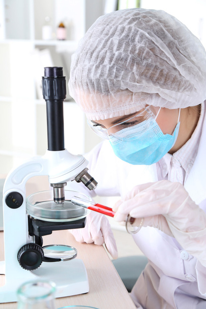 femme scientifique utilisant le microscope en laboratoire - Photo, image