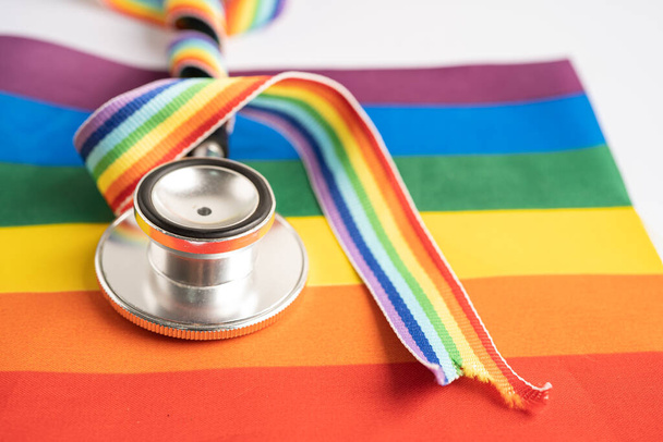 Stethoscope στο φόντο σημαία ουράνιο τόξο, σύμβολο του ΛΟΑΤ μήνα υπερηφάνειας γιορτάζουν ετήσια τον Ιούνιο κοινωνική, σύμβολο των ομοφυλοφίλων, λεσβιών, αμφιφυλόφιλων, τρανσέξουαλ, τα ανθρώπινα δικαιώματα και την ειρήνη. - Φωτογραφία, εικόνα
